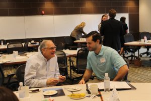 Two men talking at a table at a conference